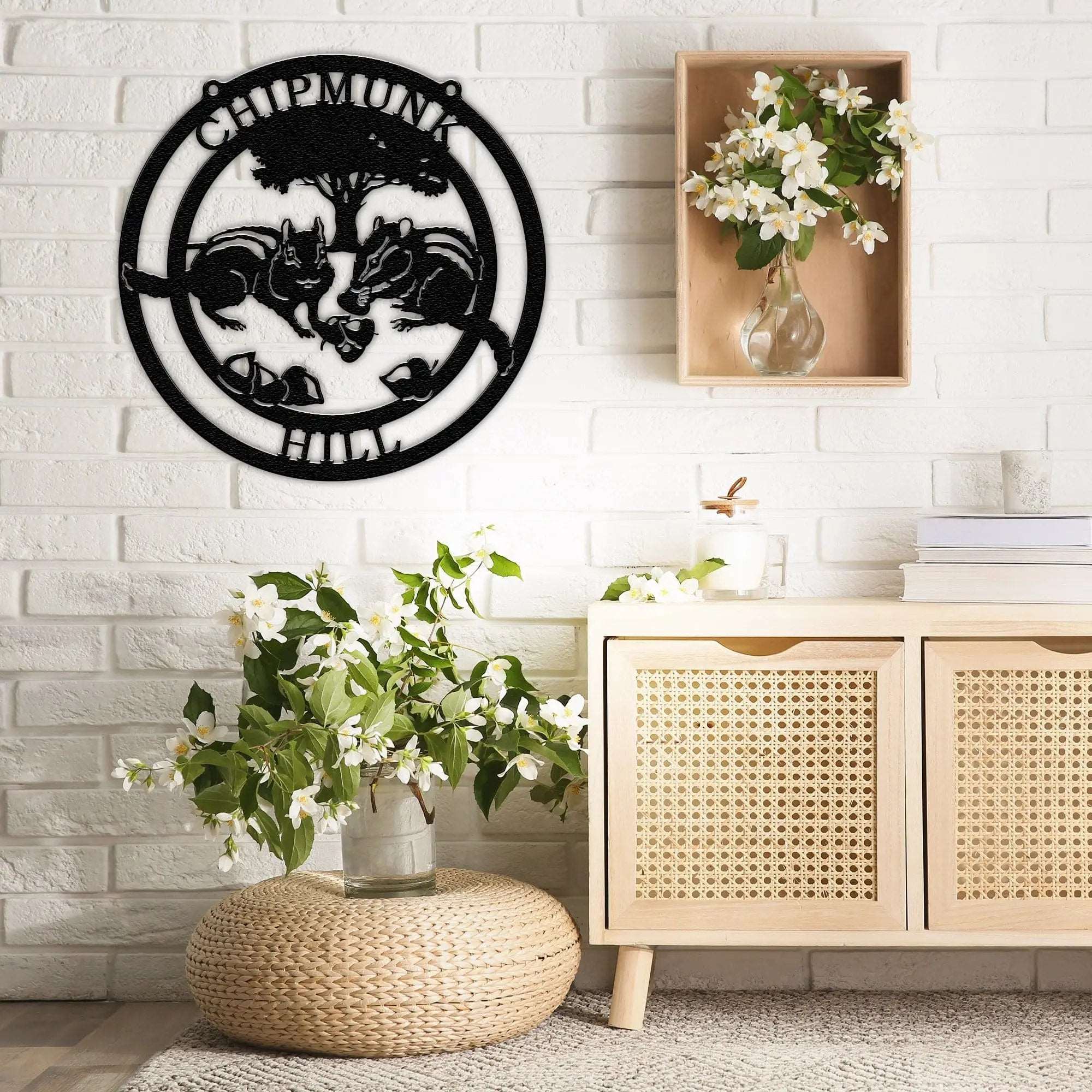Custom metal Chipmunk Crossing wall sign with "Chipmunks" text, decorative indoor wall art mounted on white brick, displayed above wooden cabinet with vase of flowers