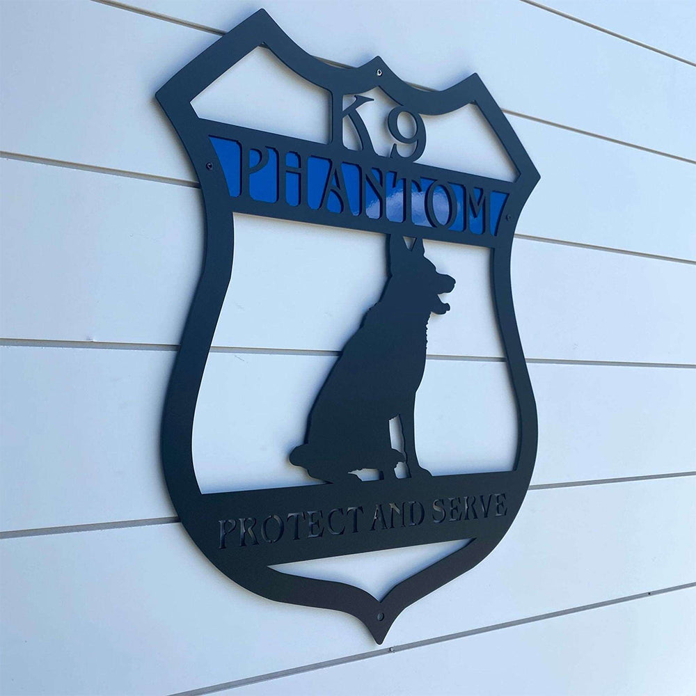Decorative metal sign featuring a dog silhouette and the text “K9 Phantom Protect and Serve,” displayed on a white wooden background, highlighting bold design and durable craftsmanship.