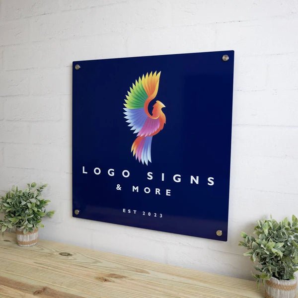 Metal logo sign featuring a colorful bird design on a dark blue background, mounted on a white brick wall, showcasing vibrant colors and durable metal craftsmanship.