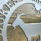 Close-up custom goat metal sign with metallic goat silhouette and 'Krebs' branding on wooden background for farmhouse décor