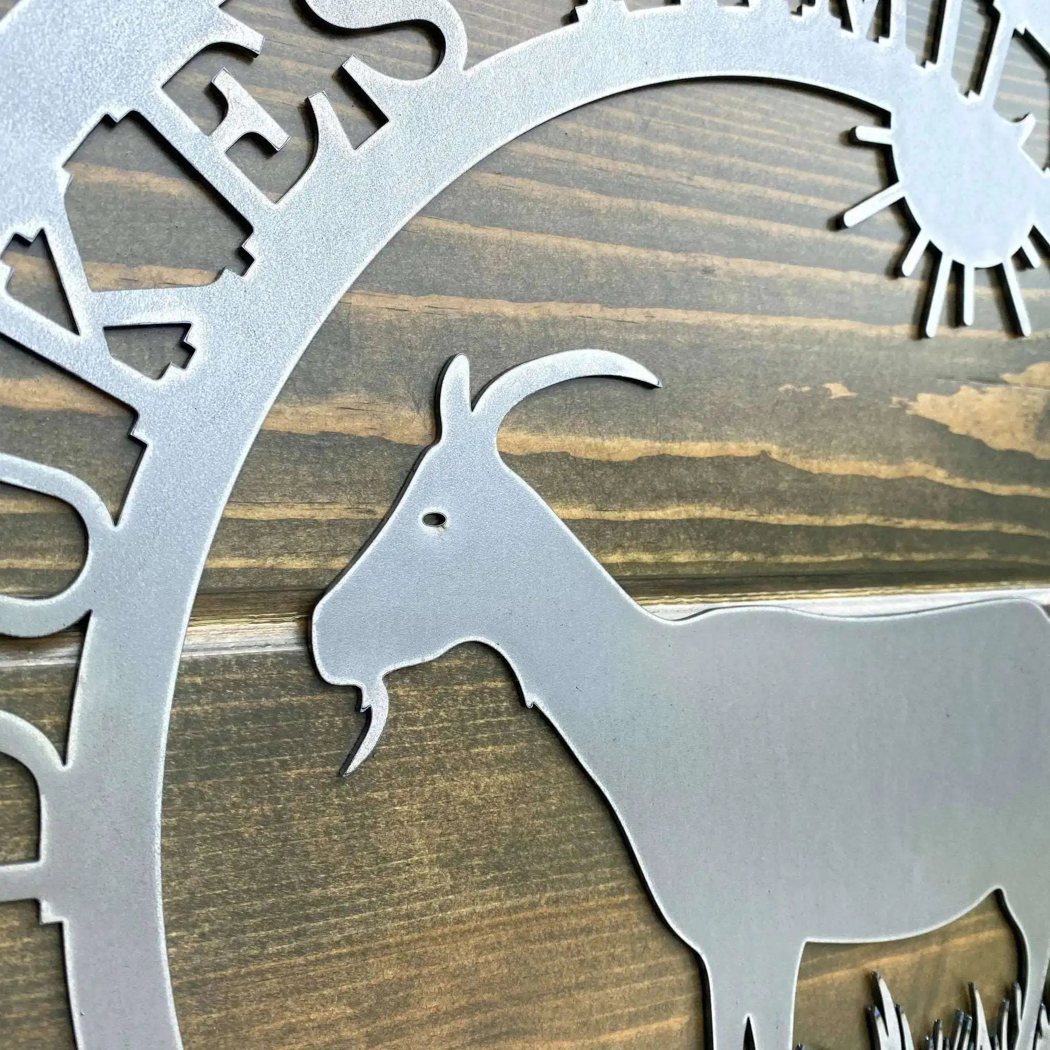 Close-up custom goat metal sign with metallic goat silhouette and 'Krebs' branding on wooden background for farmhouse décor