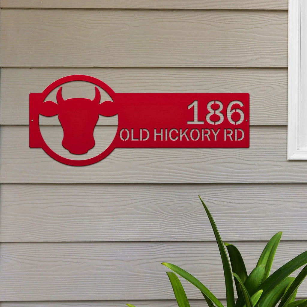 Custom red house address metal plaque with bull logo, mounted on beige wall, front door outdoor sign, modern street déco