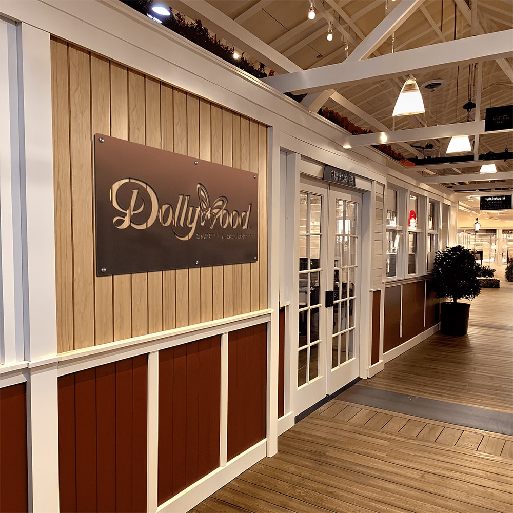 Custom laser-cut metal Dollywood sign, decorative indoor wall art mounted on wooden wall, powder coated plaque for business or entertainment space
