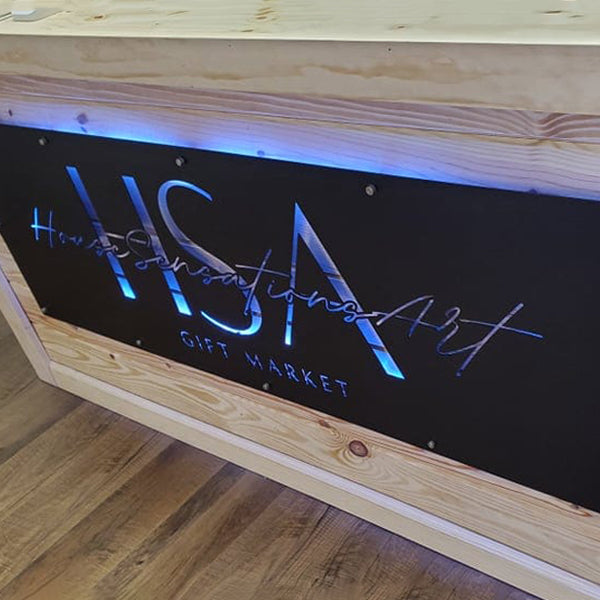 Custom matte black LED metal sign with blue illuminated text, personalized powder coated steel wall art displayed in wooden case, modern business logo sign for front door or outdoor entry décor