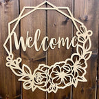 Decorative wooden “Welcome” sign with floral designs on wooden background, custom indoor or outdoor home décor accent