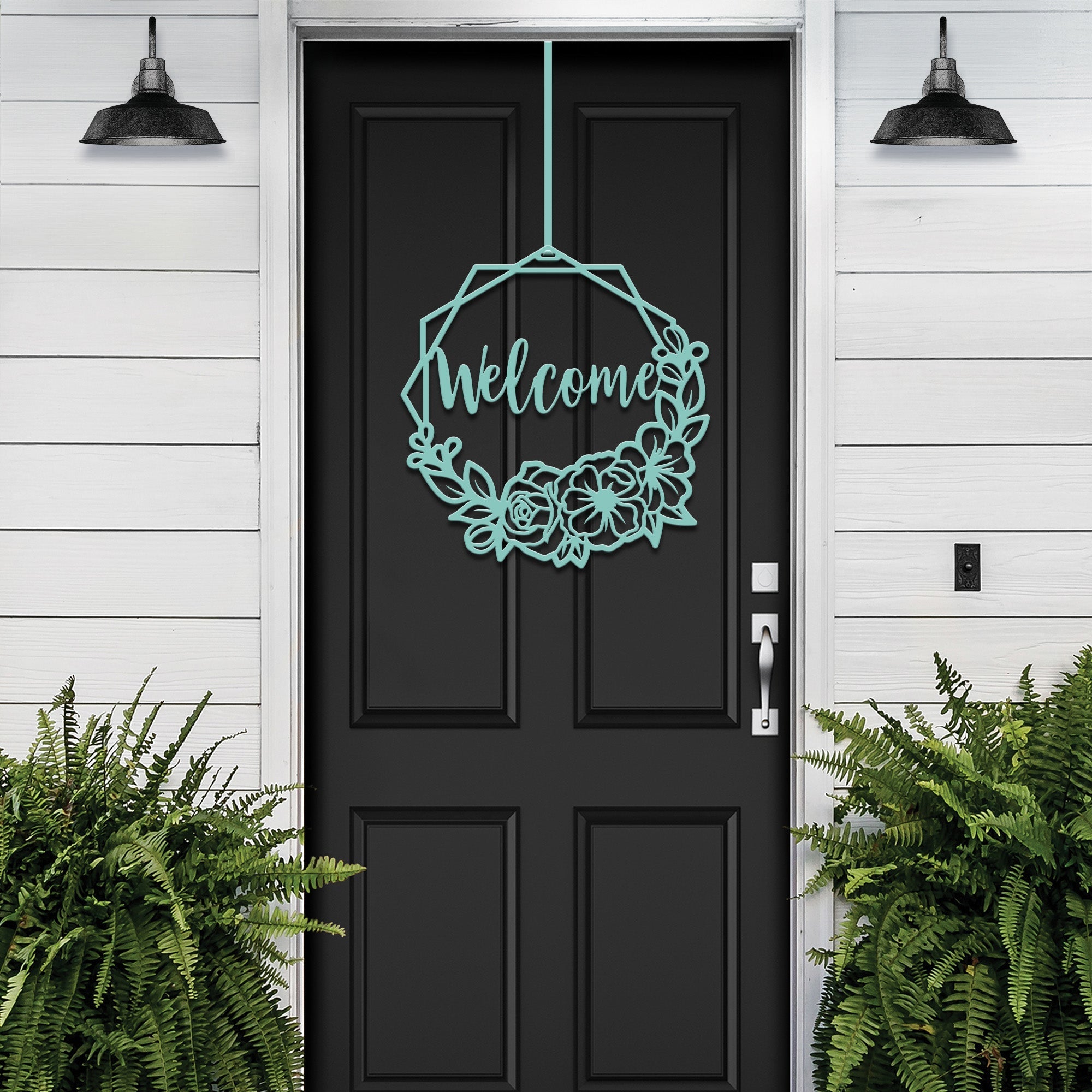 Black door with decorative “Welcome” sign on white wall with surrounding plants, custom outdoor home entrance décor