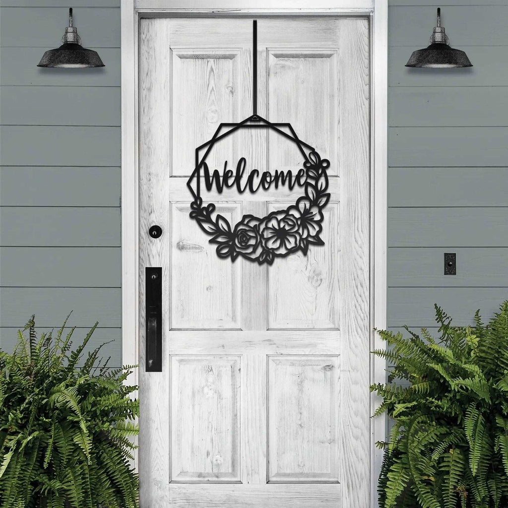 Decorative metal “Welcome” sign on white wooden door with surrounding greenery, custom outdoor home entrance décor