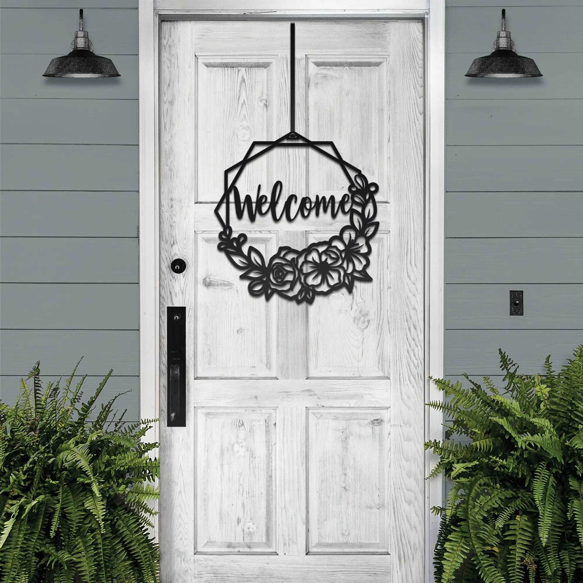 Decorative metal “Welcome” sign on white wooden door with surrounding greenery, custom outdoor home entrance décor