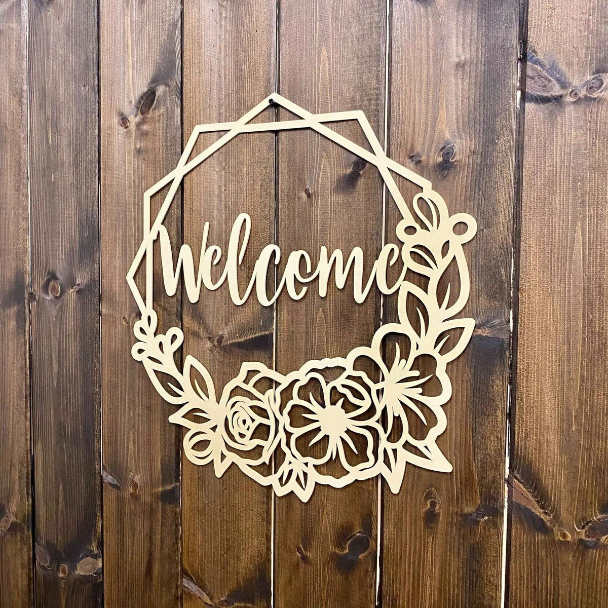 Decorative metal “Welcome” sign with floral designs on wooden background, custom indoor or outdoor home décor accent