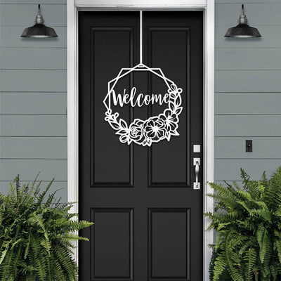 Black door on gray house exterior with “Welcome” wreath decal, decorative outdoor home entrance accent