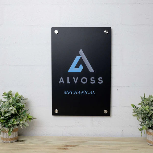 Black vertical plaque with sky blue and grey "ALVOSS MECHANICAL" text and abstract "A" logo, mounted with four corner fasteners.