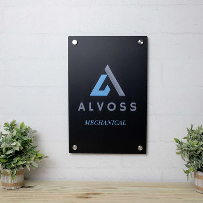 Black vertical plaque with sky blue and grey "ALVOSS MECHANICAL" text and abstract "A" logo, mounted with four corner fasteners.