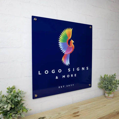 Side view of square sign with colorful bird logo, 'LOGO SIGNS & MORE' and 'EST 2023,' wall-mounted with screws.