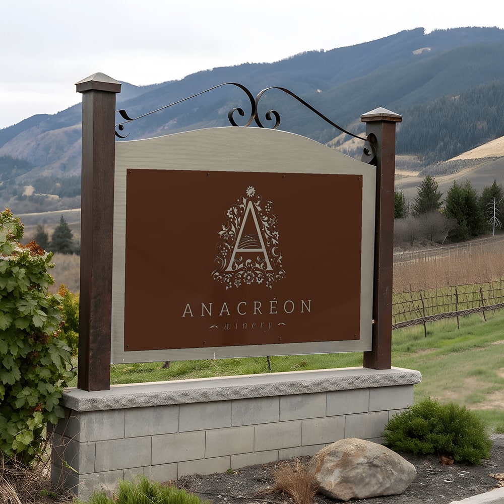 Custom monument sign for Anacreon Winery displayed outdoors with mountains in the background