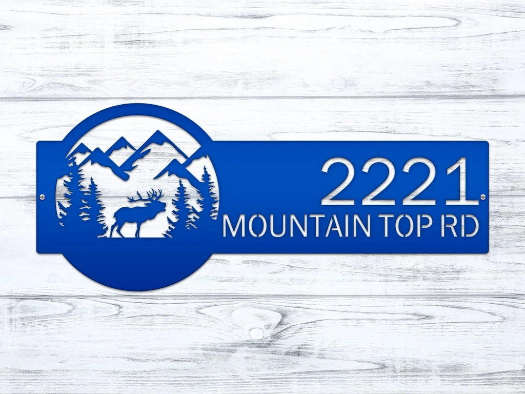 Blue metal custom moose address sign with mountain and deer design on white wooden background, rustic outdoor cabin decor