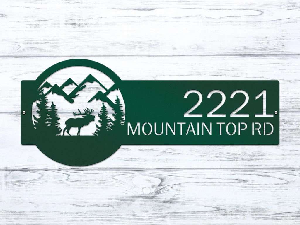 Decorative house number sign with mountains, trees, and moose design on wooden background, rustic outdoor cabin decor