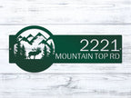 Decorative house number sign with mountains, trees, and moose design on wooden background, rustic outdoor cabin decor