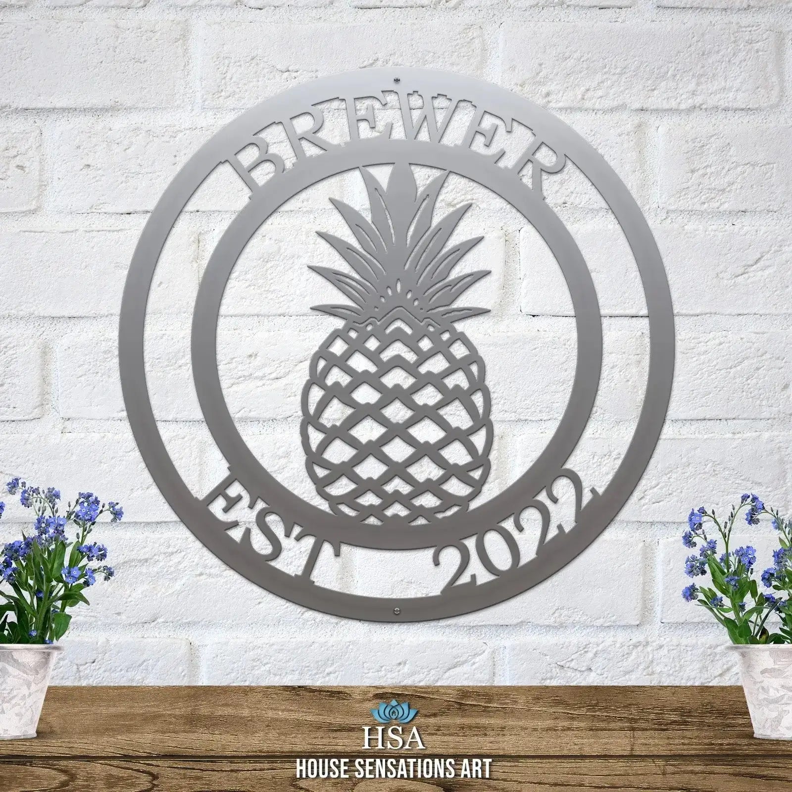 Custom Pineapple Address Sign in silver on brick wall – elegant round metal sign with pineapple design and personalized address.