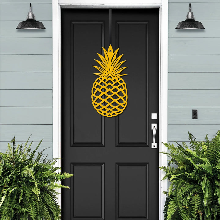 Yellow pineapple metal welcome wreath displayed on a black front door