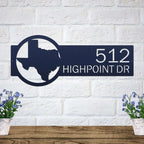 Decorative metal house number sign with Texas outline and text mounted on a white brick wall for outdoor décor, HouseSensationsArt