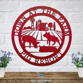 Decorative metal farm sign with pig scene and “Down at the Pig Farm Pig Resort” text on white brick wall, front door outdoor plaque, rustic décor