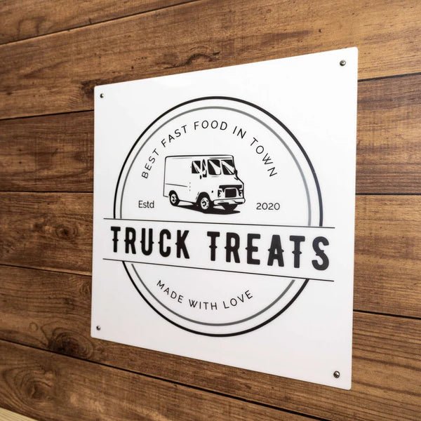 “Truck Treats” fast food truck sign on a wooden background, featuring bold, colorful lettering and a rustic, eye-catching design suitable for outdoor display.