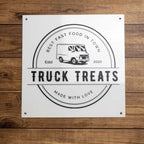 “Truck Treats” fast food truck sign mounted on a wooden background, featuring bold lettering and a rustic, inviting design perfect for outdoor display.