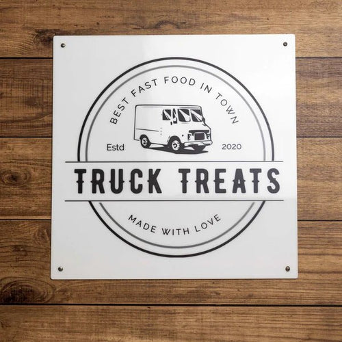 “Truck Treats” fast food truck sign mounted on a wooden background, featuring bold lettering and a rustic, inviting design perfect for outdoor display.