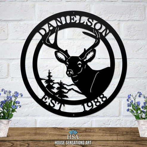 Black metal sign on light brick wall with deer head, pine tree, “EST 1988” and “DANIELSON” cut into the border.