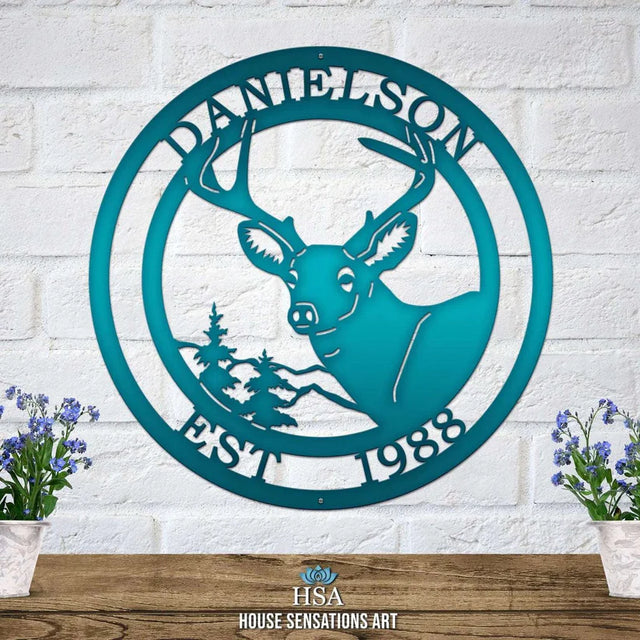 Candy teal metal sign on light brick wall with deer head, pine tree, “EST 1988” and “DANIELSON” cut into the border.