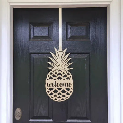 Welcome Pineapple Front Door Sign showcasing a wooden pineapple design on a black door, ideal for home décor and housewarming gifts, emphasizing warmth and hospitality.