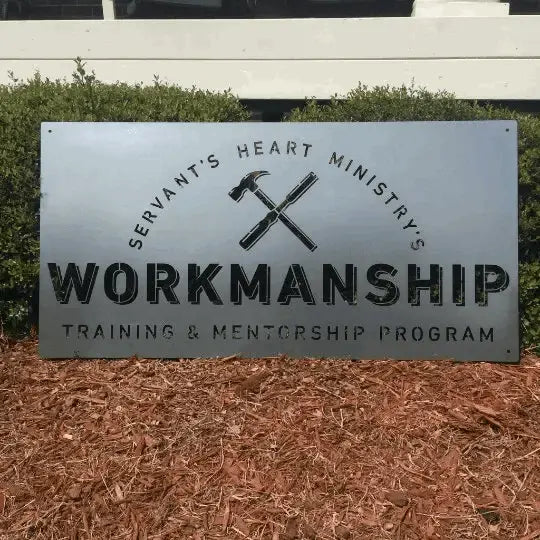 Large Outdoor Custom Business Logo Sign displayed on a white fence, showcasing a personalized design with text and hammers, exemplifying professional craftsmanship and premium cold-rolled steel construction.