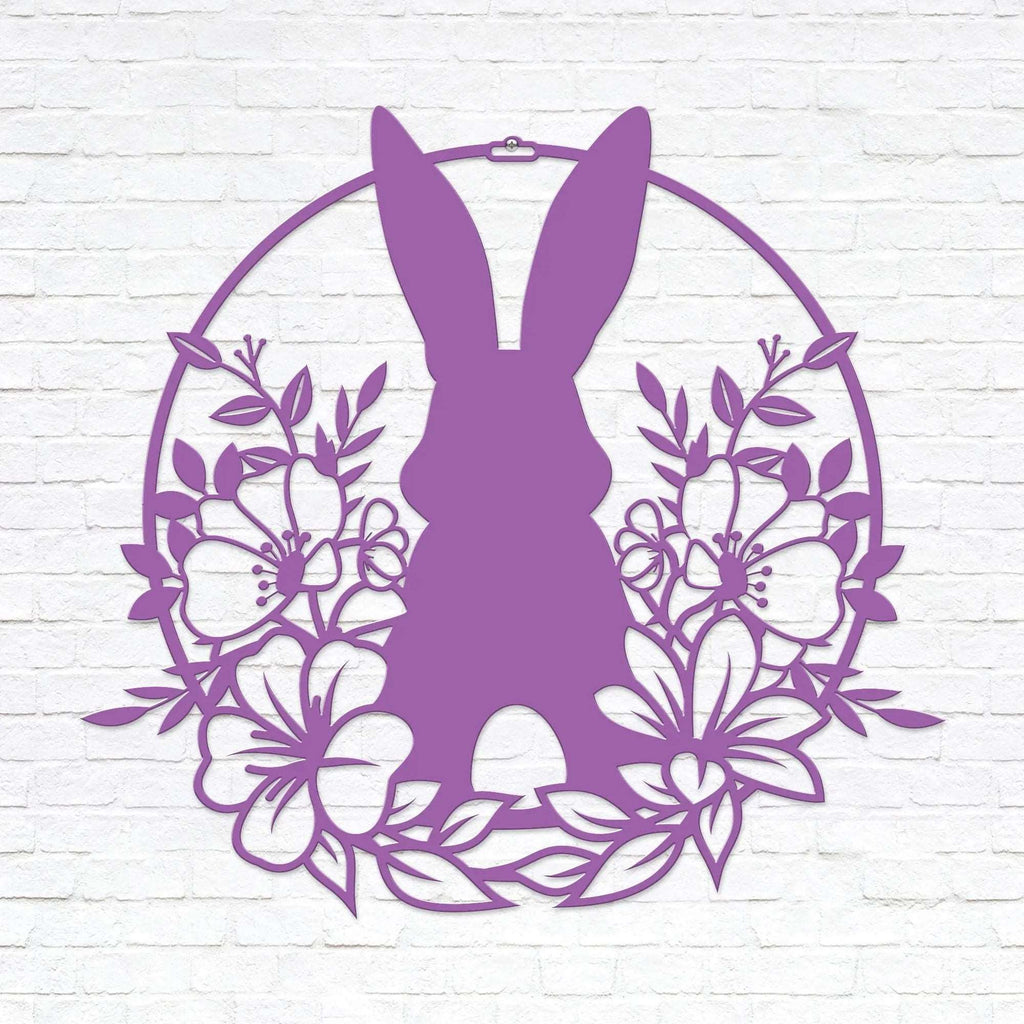 Purple Easter bunny metal wall sign with floral wreath design, custom rabbit silhouette front door décor, powder coated outdoor spring decoration, farmhouse-style Easter wall art on white brick background