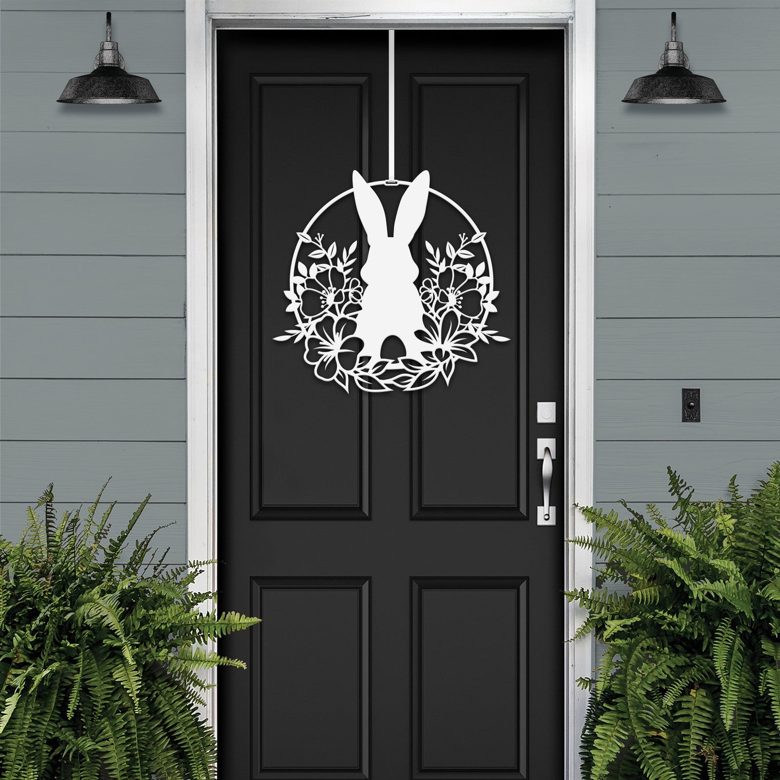 White Easter bunny metal door sign with floral wreath, custom rabbit silhouette front door décor, powder coated outdoor spring decoration, farmhouse-style Easter porch sign with greenery on black door and gray siding