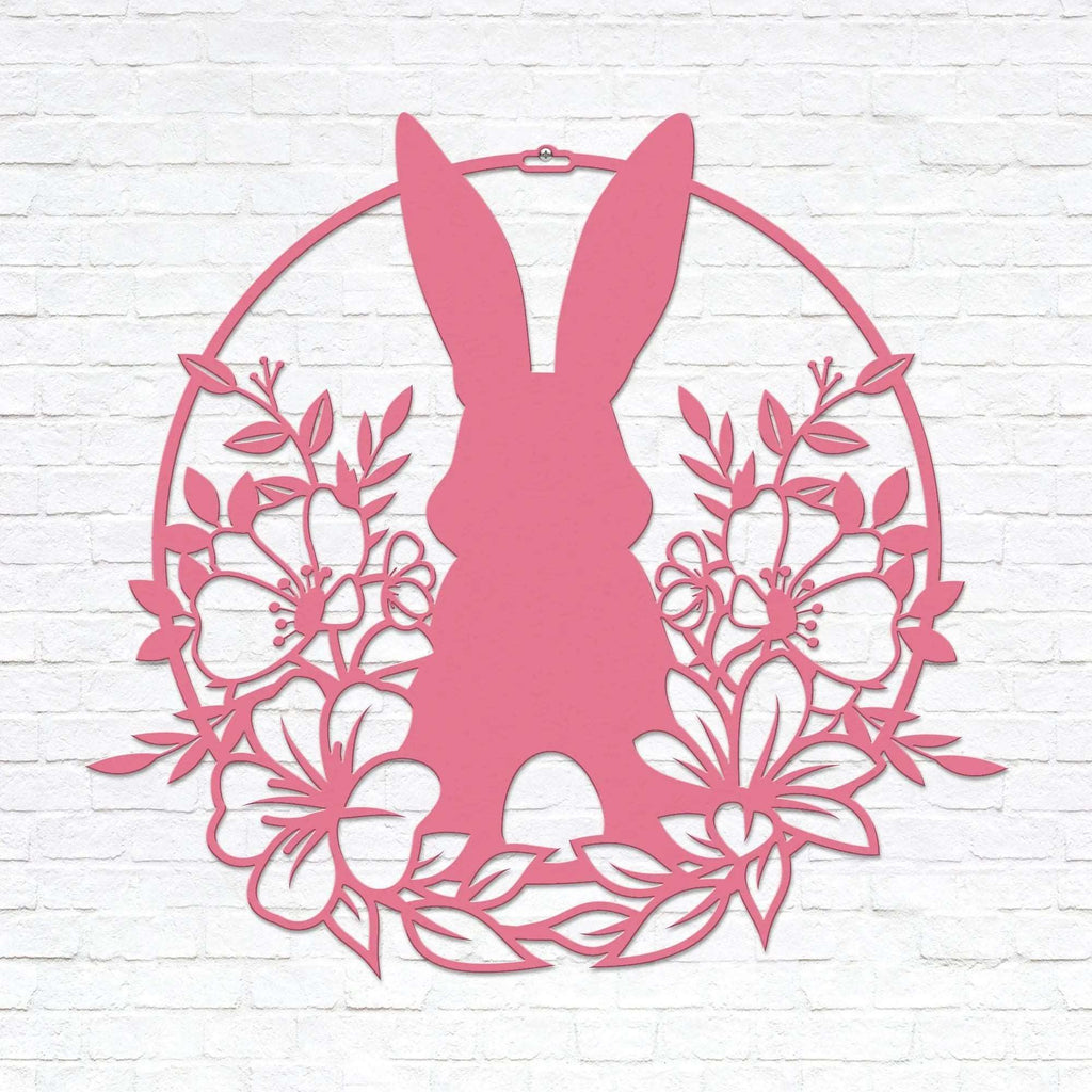 Pink Easter bunny metal wall sign with floral wreath, custom rabbit silhouette front door décor, powder coated outdoor spring decoration, farmhouse-style Easter wall art on white brick background