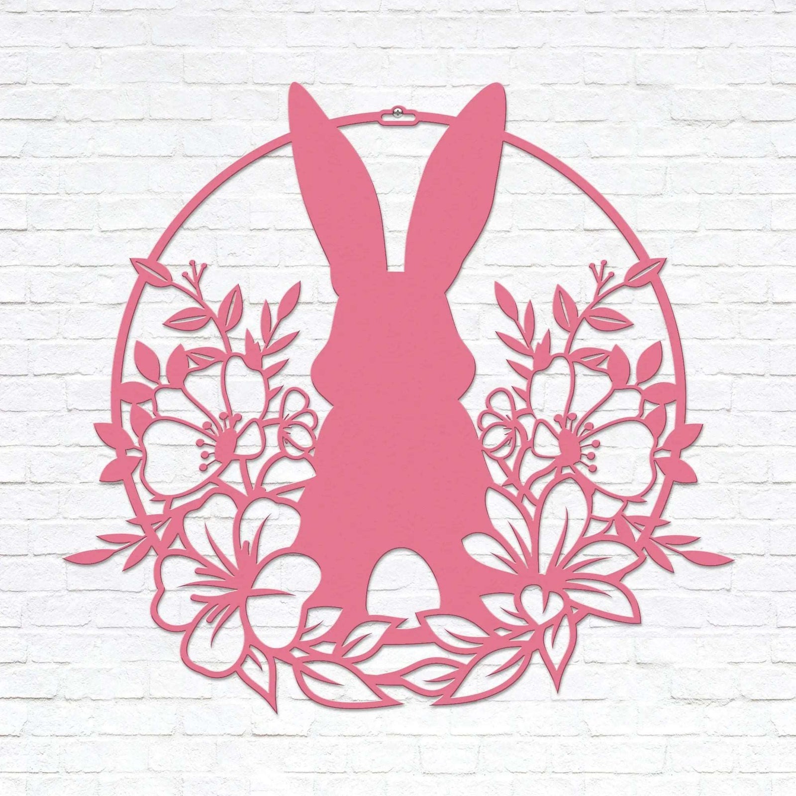 Pink Easter bunny metal wall sign with floral wreath, custom rabbit silhouette front door décor, powder coated outdoor spring decoration, farmhouse-style Easter wall art on white brick background
