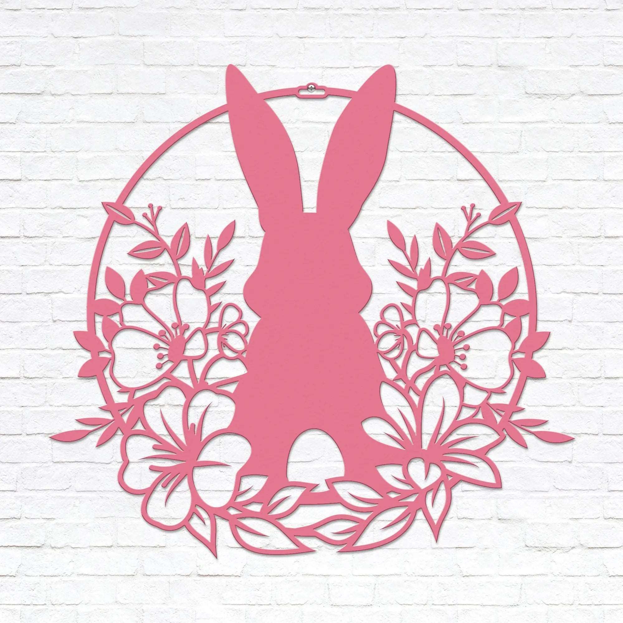 Pink Easter bunny metal wall sign with floral wreath, custom rabbit silhouette front door décor, powder coated outdoor spring decoration, farmhouse-style Easter wall art on white brick background
