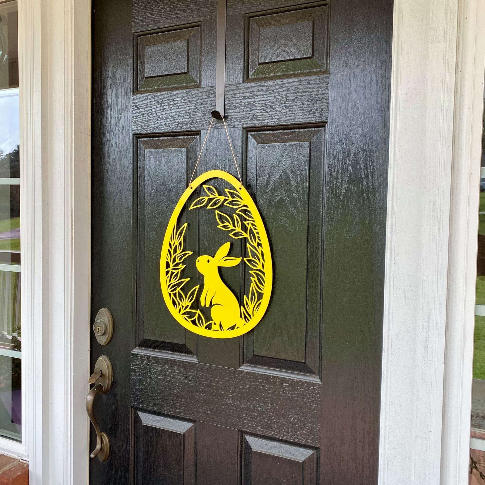 Yellow rabbit metal door hanger on dark wooden door, custom outdoor powder coated Easter décor, farmhouse spring front door sign