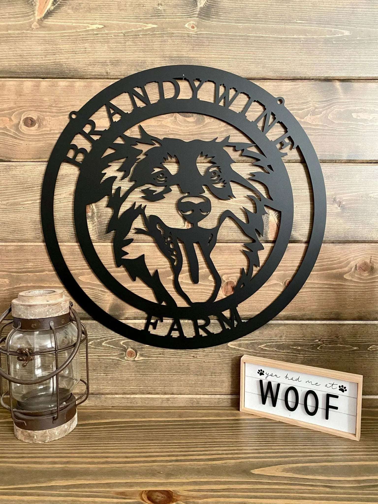 Black custom laser cut metal ranch sign with dog head silhouette and “BRANDYWINE FARM” text; mounted on paneled wall.