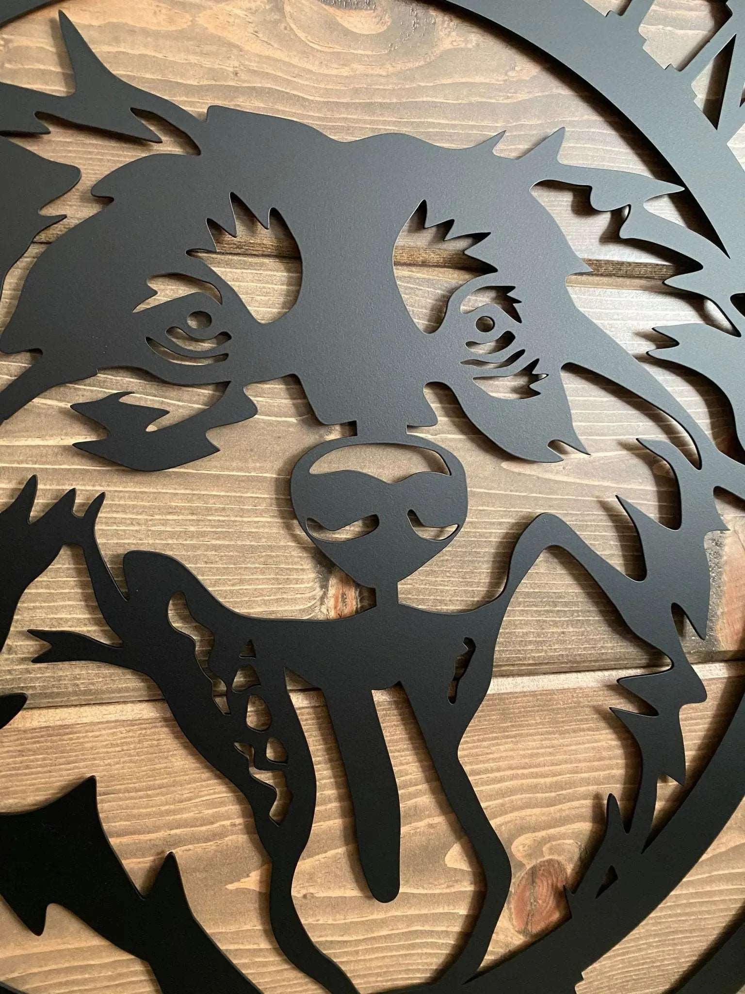 Close-up of dog head sign showing laser-cut face detail and metal texture; highlights precise craftsmanship and quality finish.