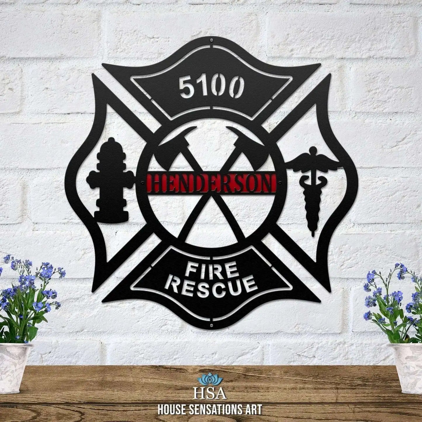 Personalized Maltese Cross Axes, Medic Address Sign displayed on a white brick wall, showcasing intricate metal craftsmanship. Perfect for home décor, this custom metal sign honors firefighters and serves as a unique housewarming gift.