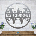 Personalized metal monogram sign featuring the last name “WILKINSON,” displayed on a white brick wall backdrop with two potted plants on either side, highlighting custom craftsmanship and stylish home décor.