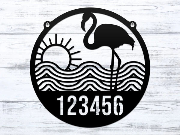 Close-up of round Black Flamingo Address Sign with house number '123456', waves, and sun design.