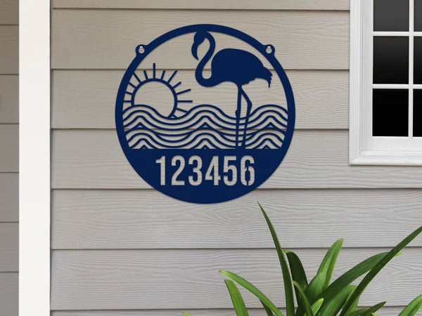 Navy Blue-colored Flamingo Address Sign with house number '123456', waves, and sun design, mounted on door with gray wall.