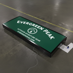 Color Green Cabinet Sign for  "Evergreen Peak" outdoor gear sign on a concrete floor