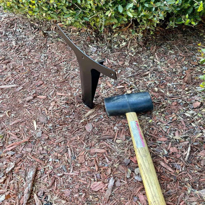 Personalized metal garden stake sign, side view outdoor décor installed in mulch bed with garden greenery in background.