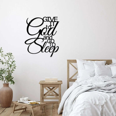 Bedroom with “Give it to God and Go to Sleep” wall decal above the bed, featuring wooden nightstand and potted plant