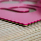 Close-up of pink object on wooden surface, highlighting texture and decorative details for home décor or custom signage