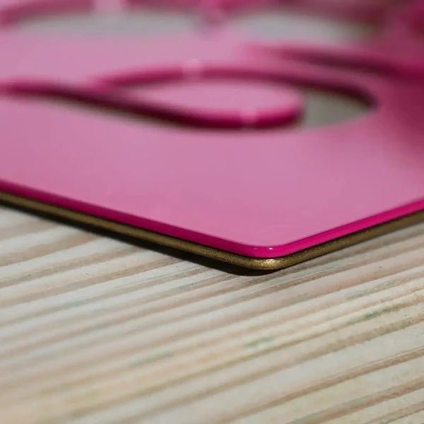 Close-up of pink object on wooden surface, highlighting texture and decorative details for home décor or custom signage