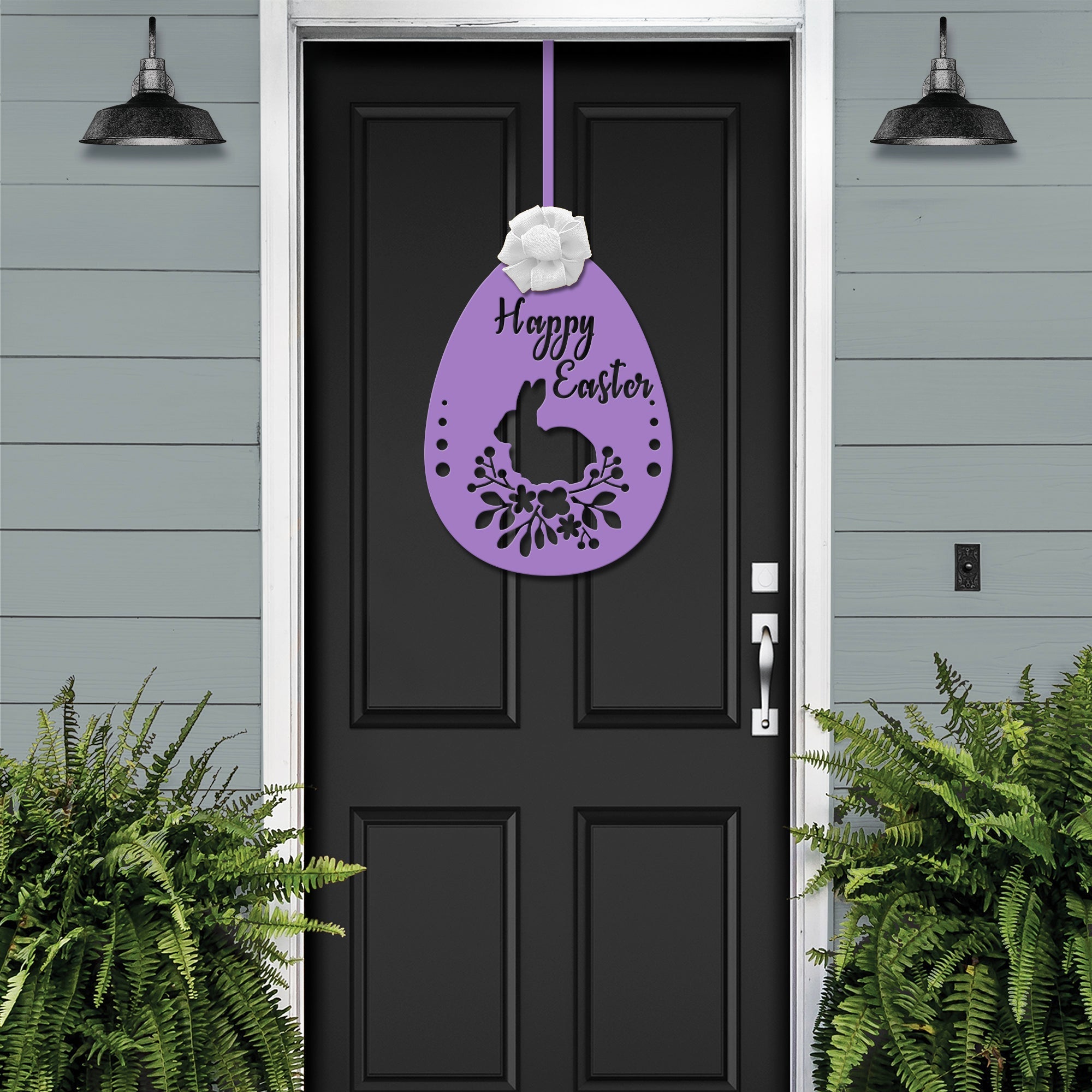 Black front door with purple Easter egg metal welcome sign, gray exterior wall and green plants, seasonal farmhouse décor, custom powder coated entry wall art sign